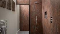 Embellished in beautiful copper panels is the en suite bathroom