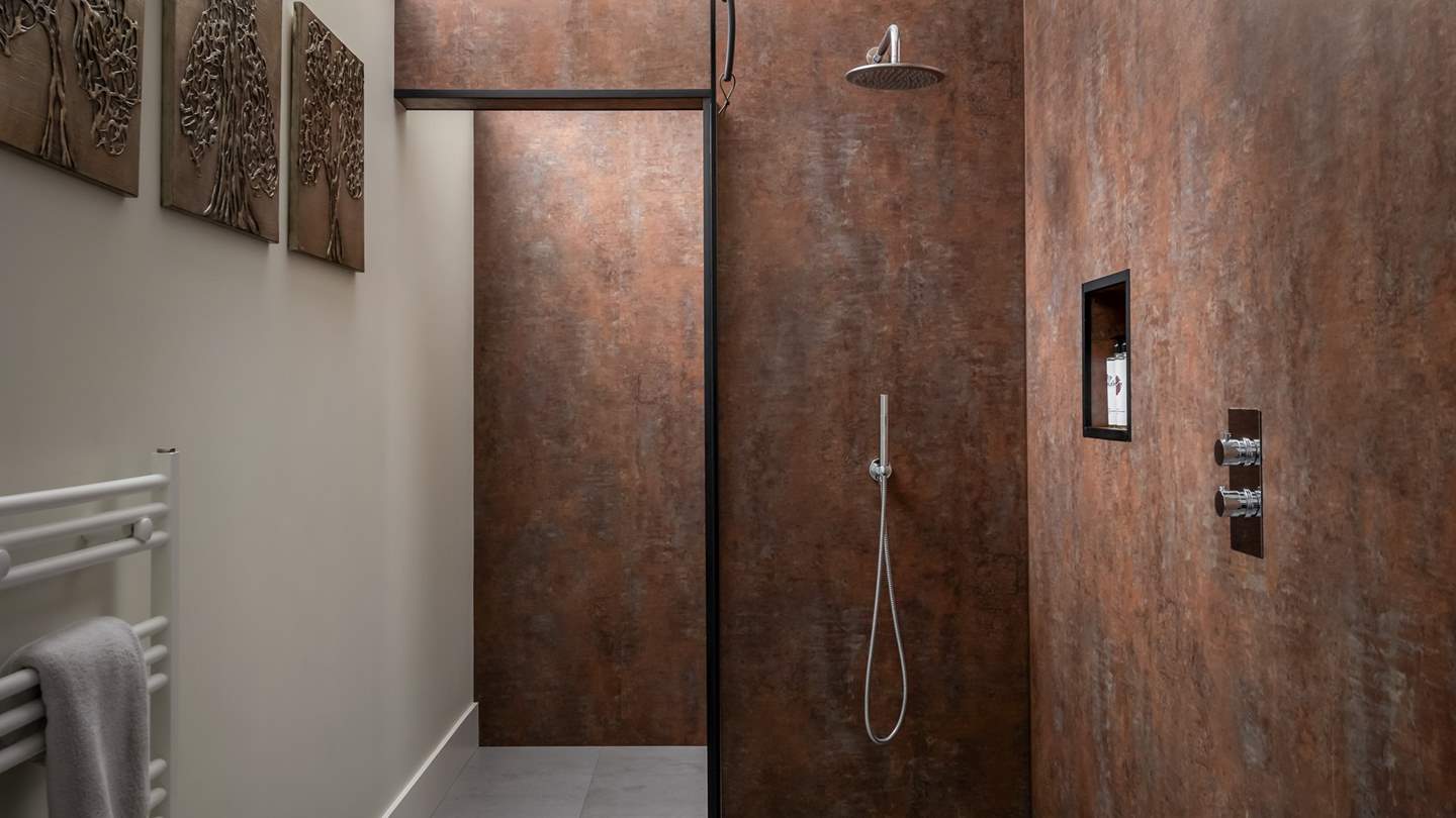 Embellished in beautiful copper panels is the en suite bathroom