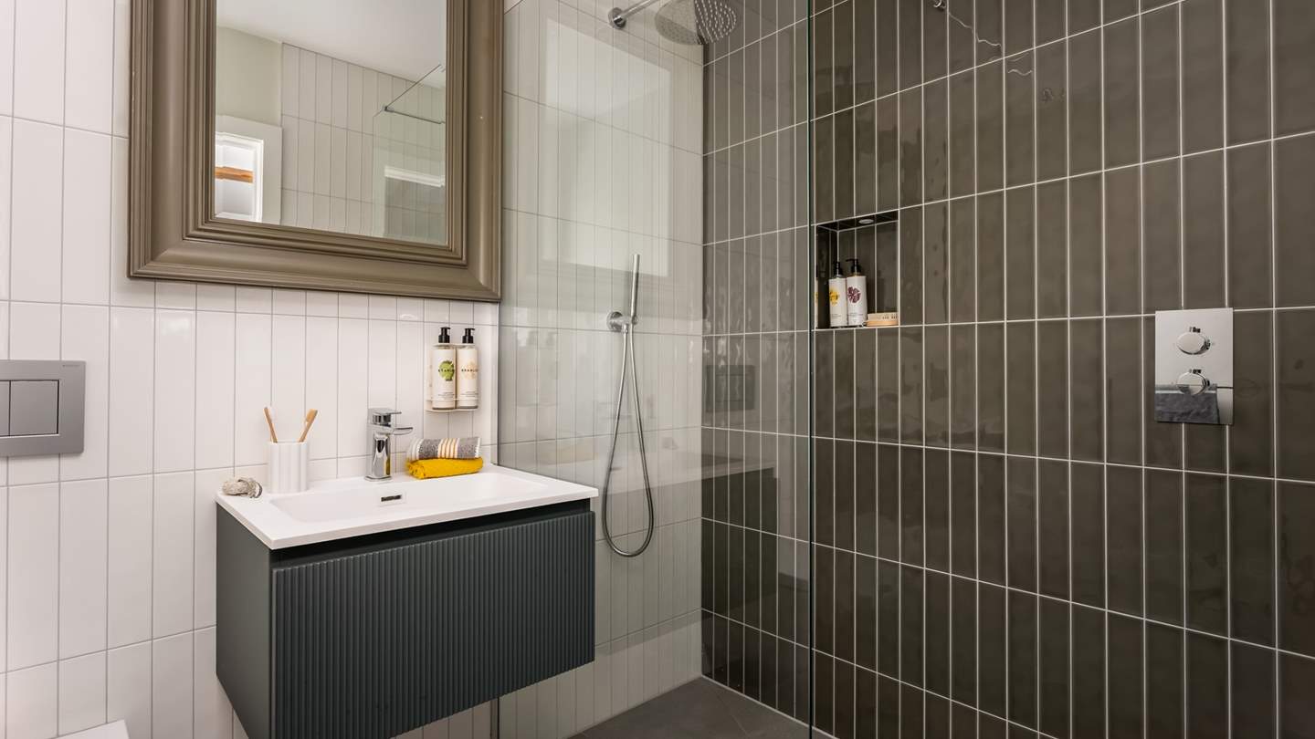 An additional shower and toilet can be reached from the hallway for soothing self-care rituals