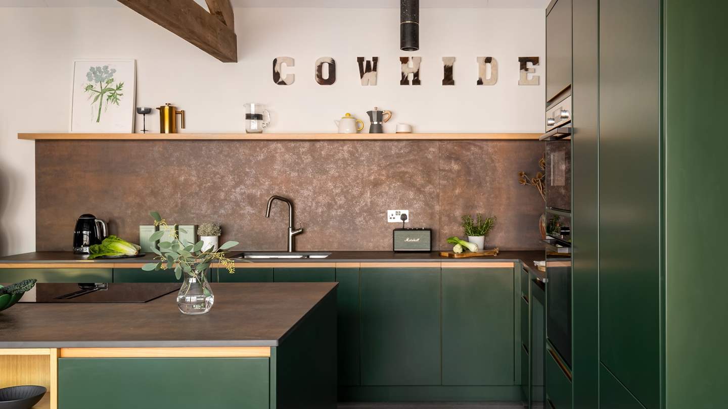 Adorned in forest greens and copper tones, the kitchen features everything you need for preparing feasting dishes