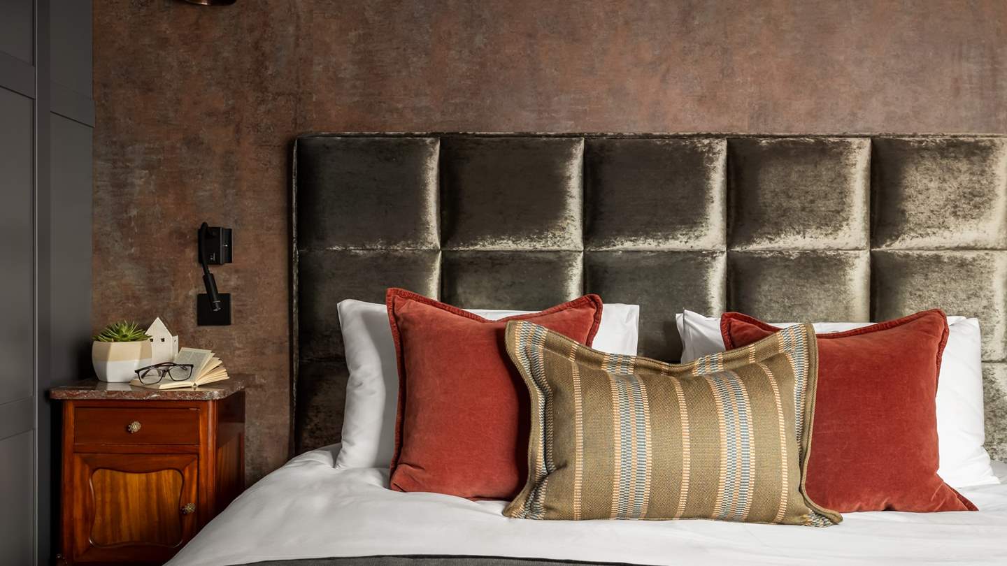 A king size bed is enswathed in the finest linens and throws