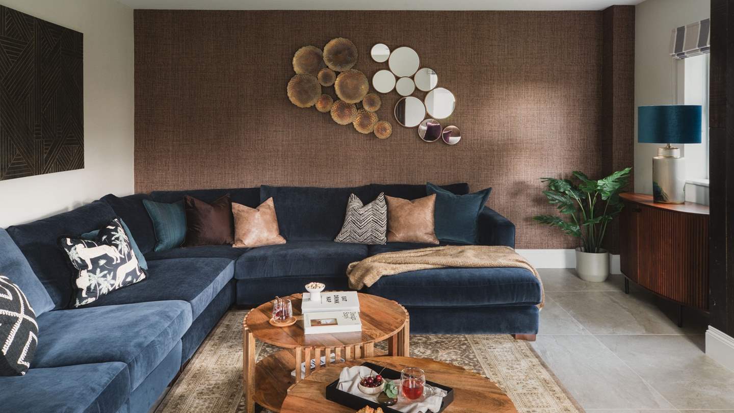This space is complete with a navy velvet, L-shaped sofa and an armchair