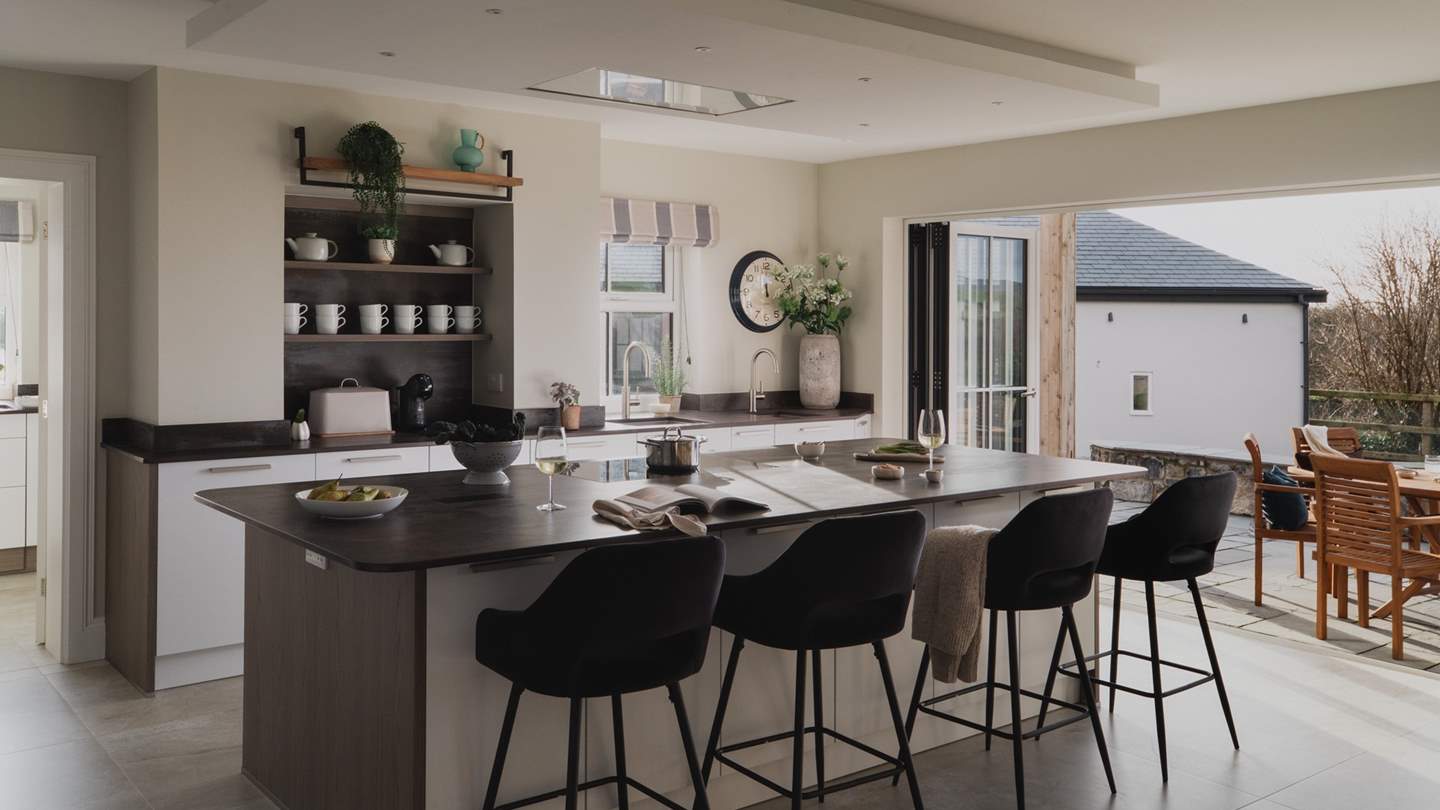 An array of floor-to-ceiling bifold doors lead to the wraparound terrace and spacious garden