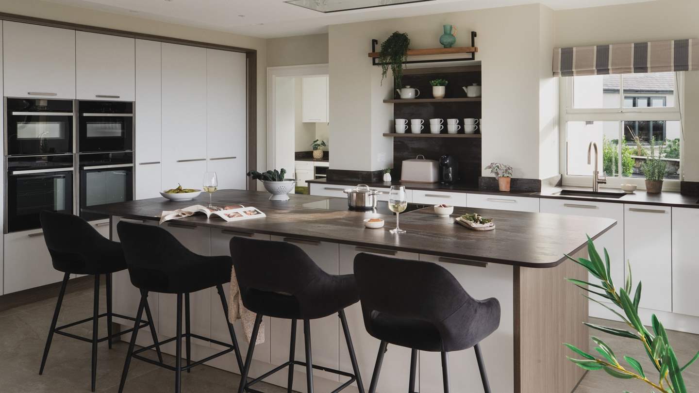 Taking centre stage is a spacious stone-topped island, gathered by four breakfast stools