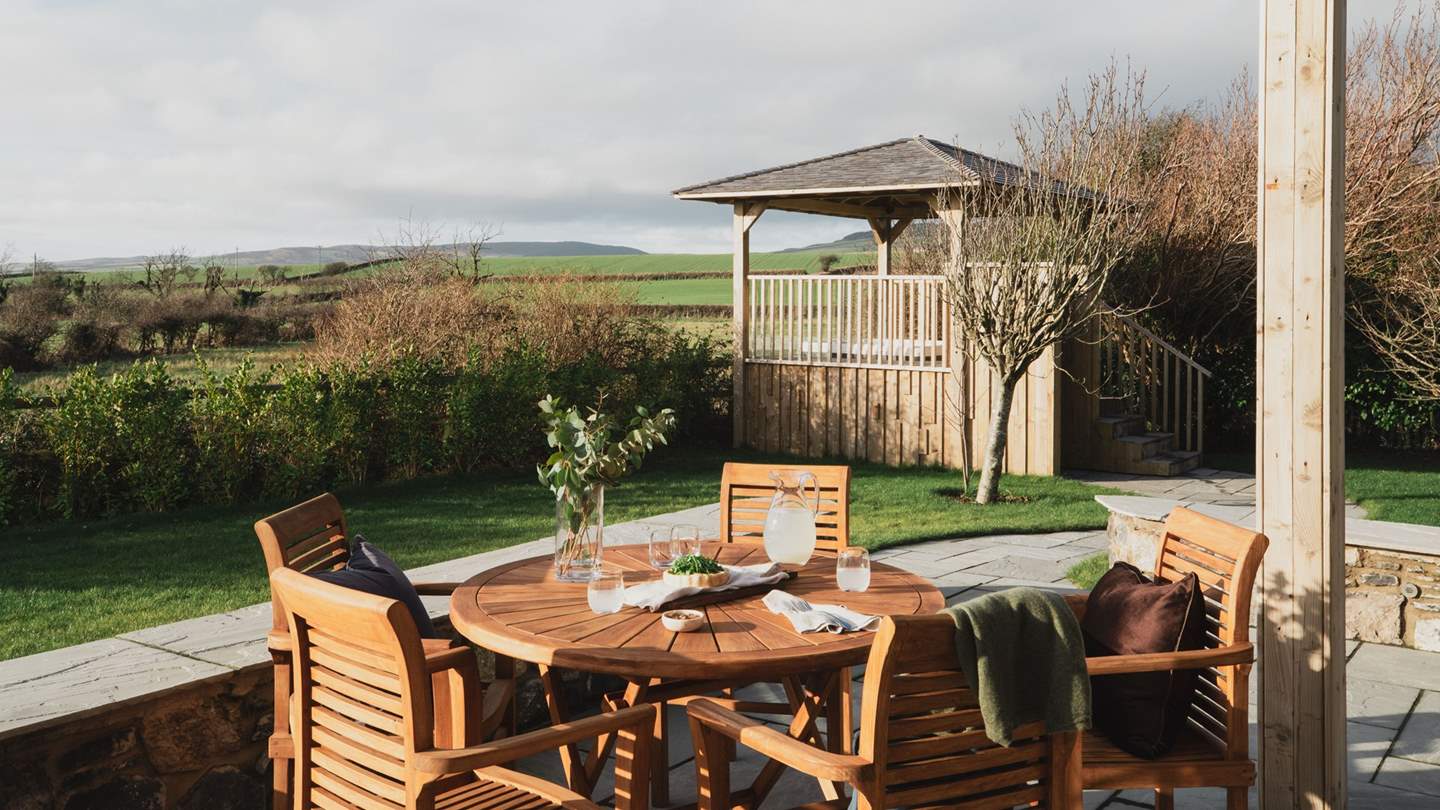 A wooden table and chairs on the terrace promise shaded mealtimes below the balcony