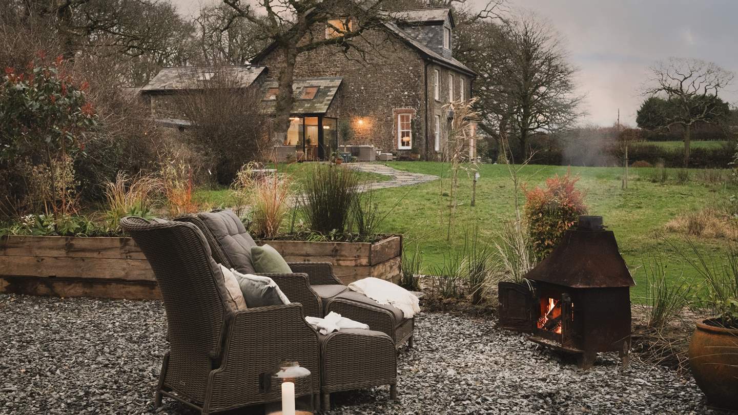 A reclaimed wood burner, beautifully transformed into a firepit, promises a soothing spot to unwind after dark