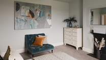 The room is styled in soothing shades of blue, complementing the abstract artwork
