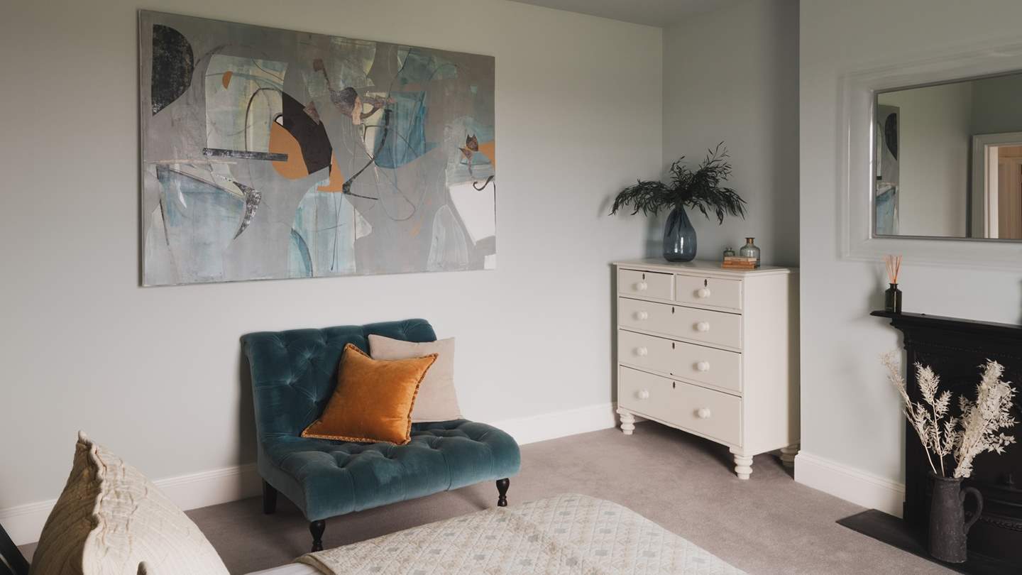 The room is styled in soothing shades of blue, complementing the abstract artwork