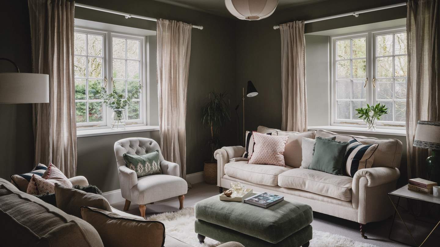 Across the hall, an inviting cinema room is drenched in rich earthy tones