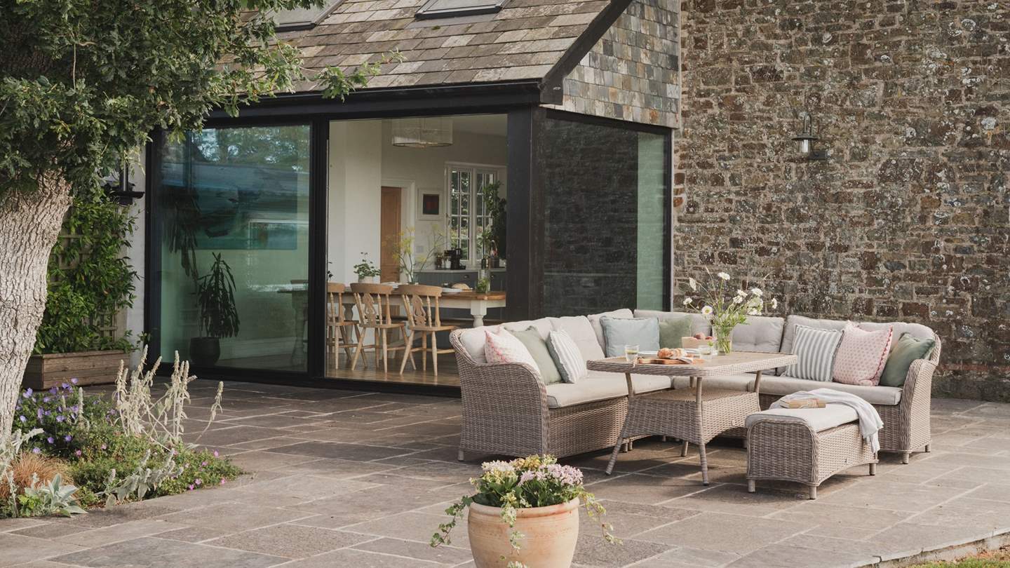 A sun dappled patio sits beyond the dining space