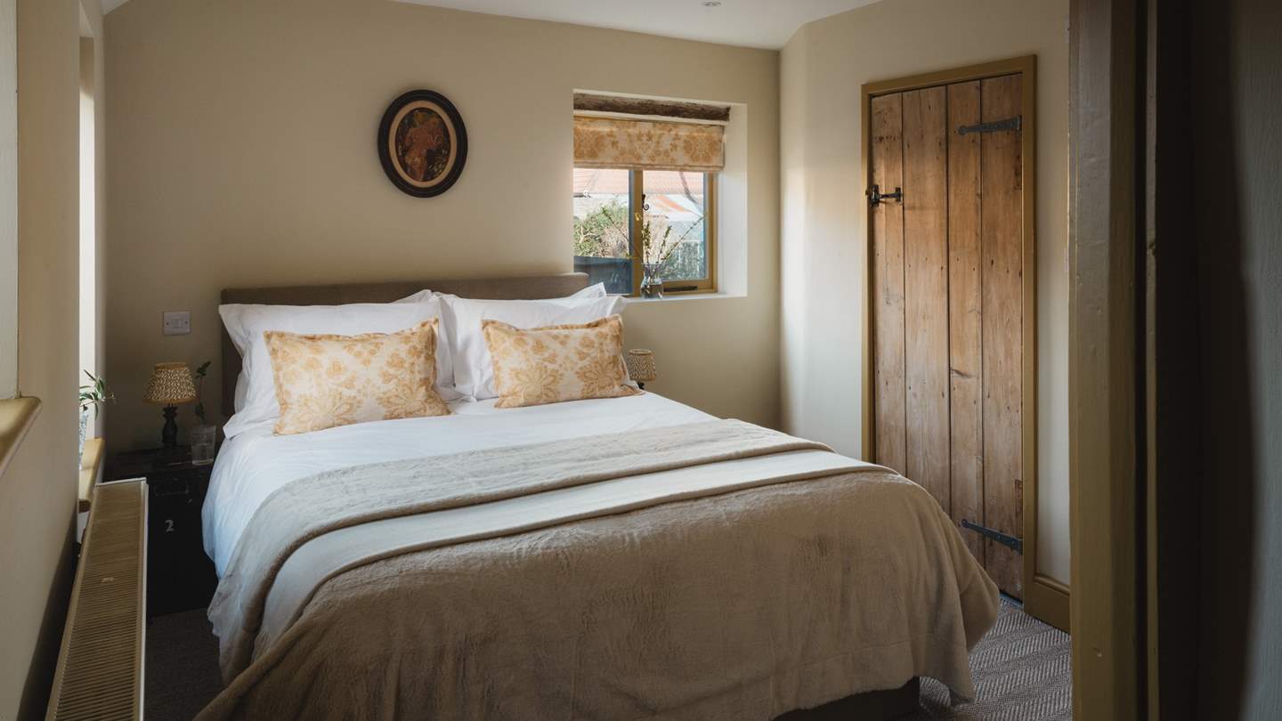 Promising cosy carpet and butter-yellow accents, the first bedroom is complete with a king-size bed