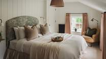 A king-size bed topped with soft linen tempts for breakfast in bed