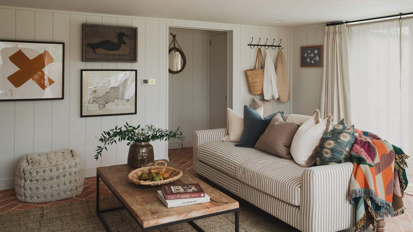 The snug living space is light filled yet endlessly cosy, with considered antique pieces at every turn