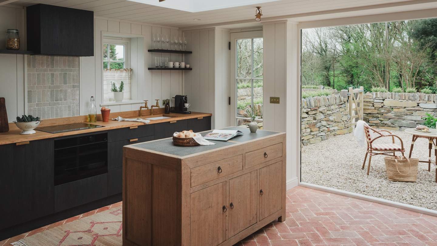 Rustic herringbone terracotta tiles set the scene for culinary crafting in the calming kitchen