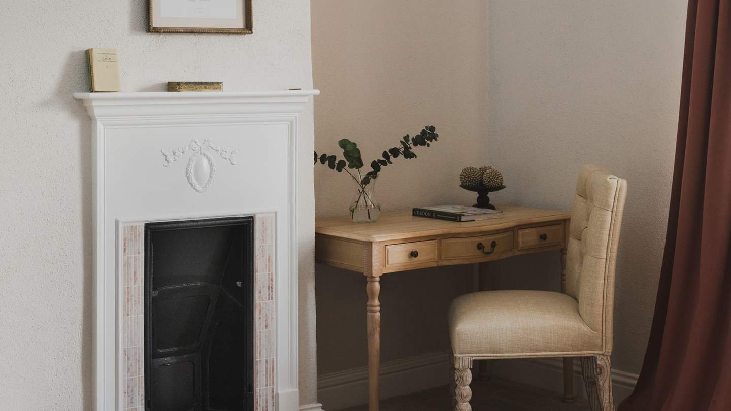 Uncover the original fireplace beside the writing desk