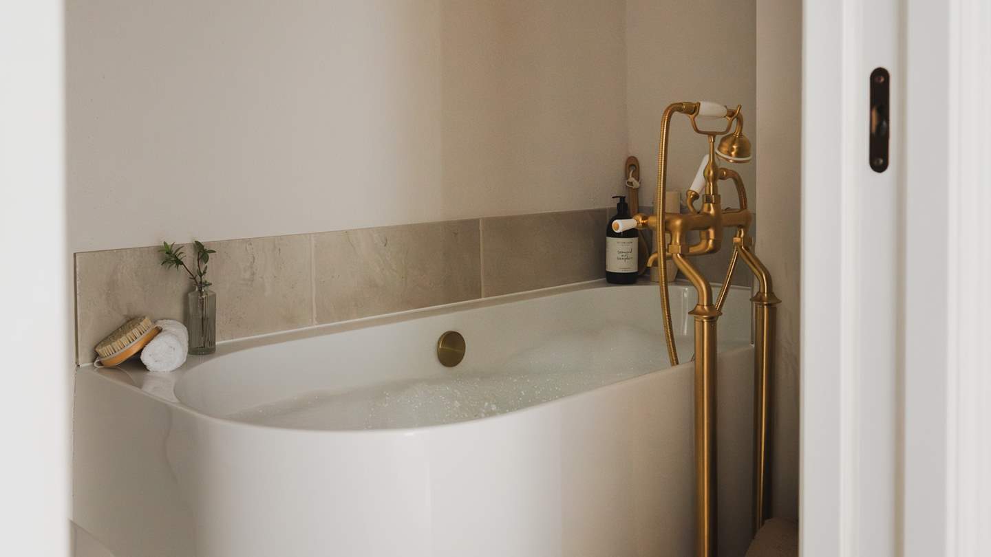This beautiful bathroom features both a walk-in rainfall shower and a separate bath for tranquil bubble-topped soaks