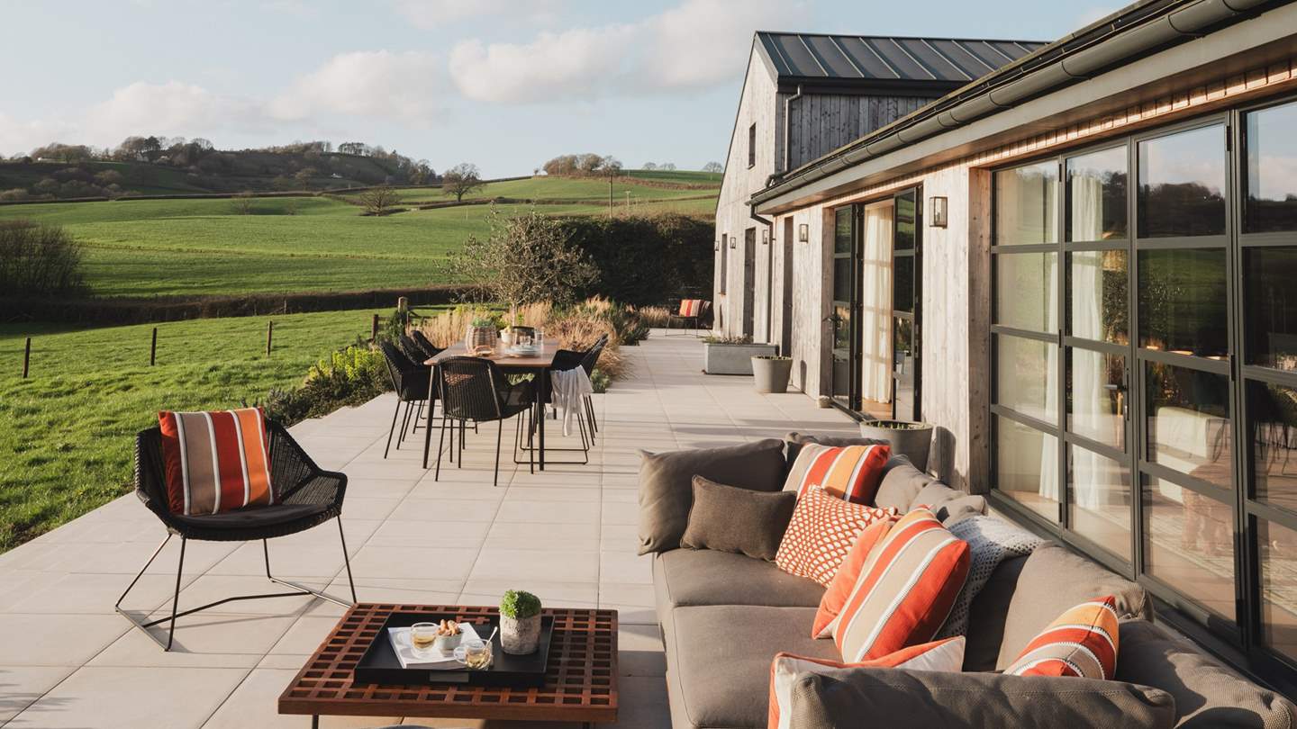 Perfect for relaxing with a book or beverage in hand, an outdoor Minotti L-shaped sofa is arranged around a teak coffee table 