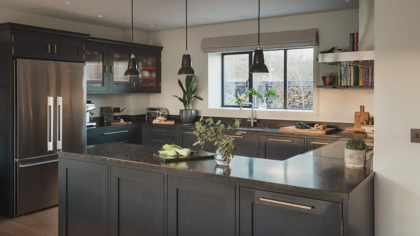 Bespoke cabinetry in Farrow & Ball Railings provides generous room for culinary preparation