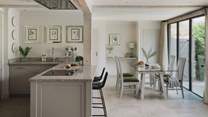 Inviting four to dine comfortably, a glass-topped dining table rests at the far side of the space
