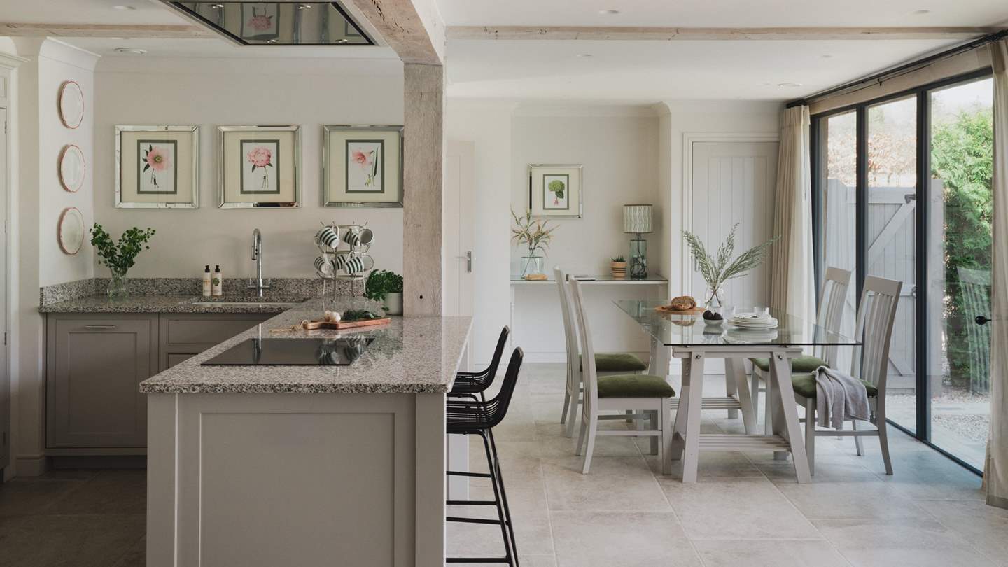 Inviting four to dine comfortably, a glass-topped dining table rests at the far side of the space