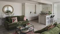 In an open plan layout, the living, kitchen, and dining space is bathed in natural light