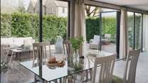Floor to ceiling bi-fold doors frame the open plan living, kitchen, and dining space