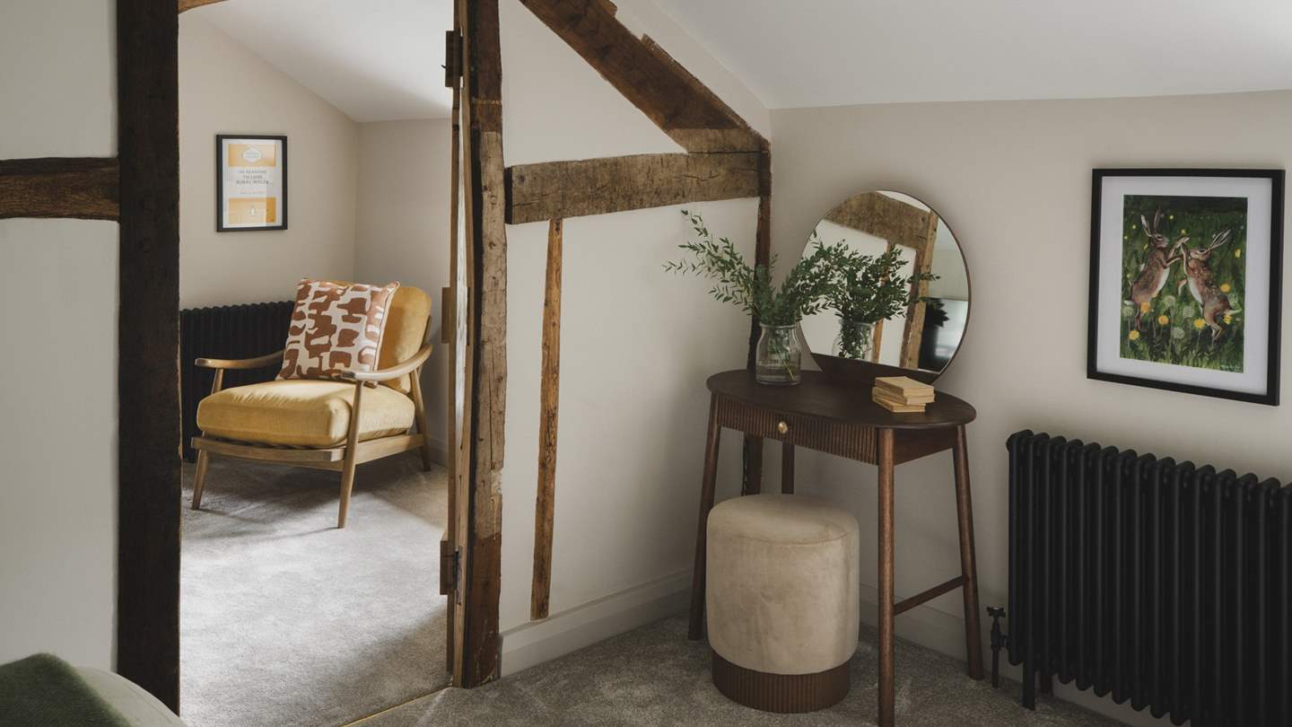 This room also features a dressing table and stool for morning rituals