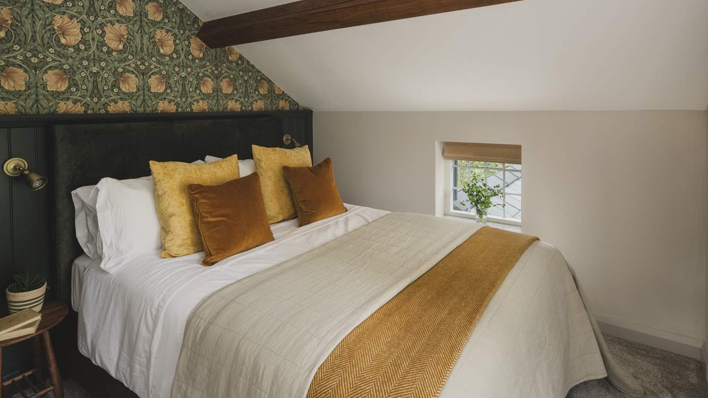 The second bedroom features elegant William Morris Pimpernel print wallpaper and rich tones