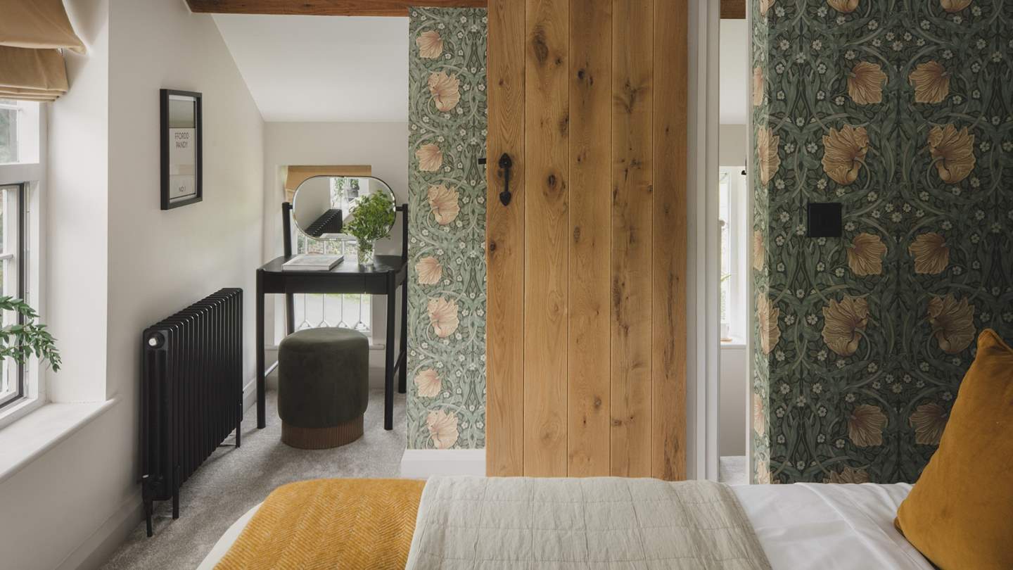 This room has a dressing table and stool, an ottoman bed for additional storage and a clothing rail for garments