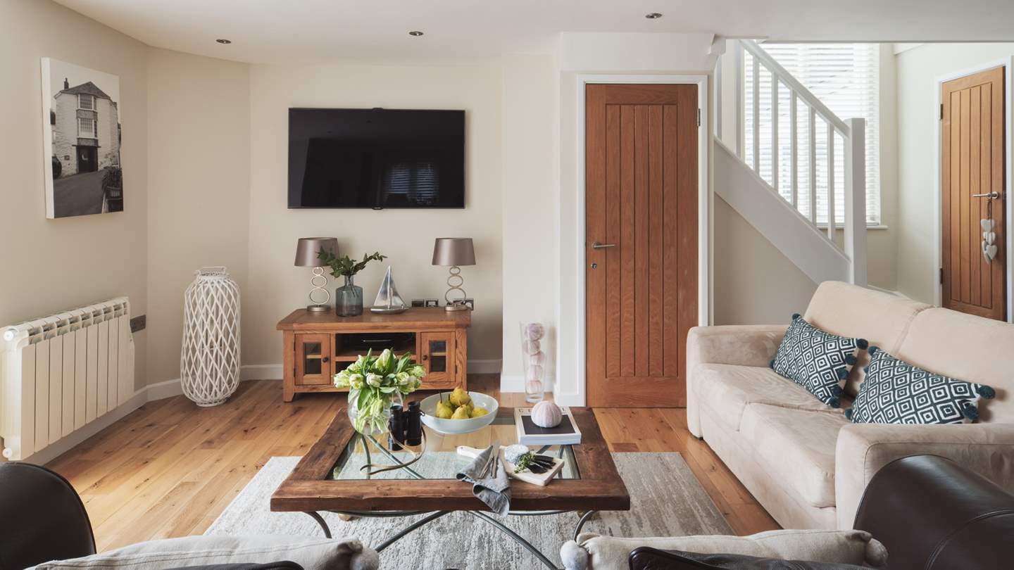 Overlooking Portloe's harbour, the open-plan living space showcases custom-made bi-fold doors which open to greet the sea and allow balmy breezes to drift in during the warmer months