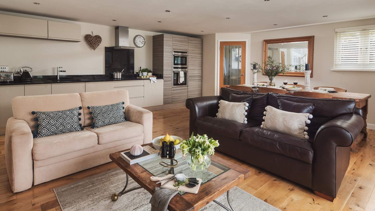 The fully equipped kitchen features a line of sleek cabinets topped with mottled granite worktops with ample room to prepare platters