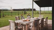Lending a comfortable space for decadent dining is an outdoor dining table and chairs for eight