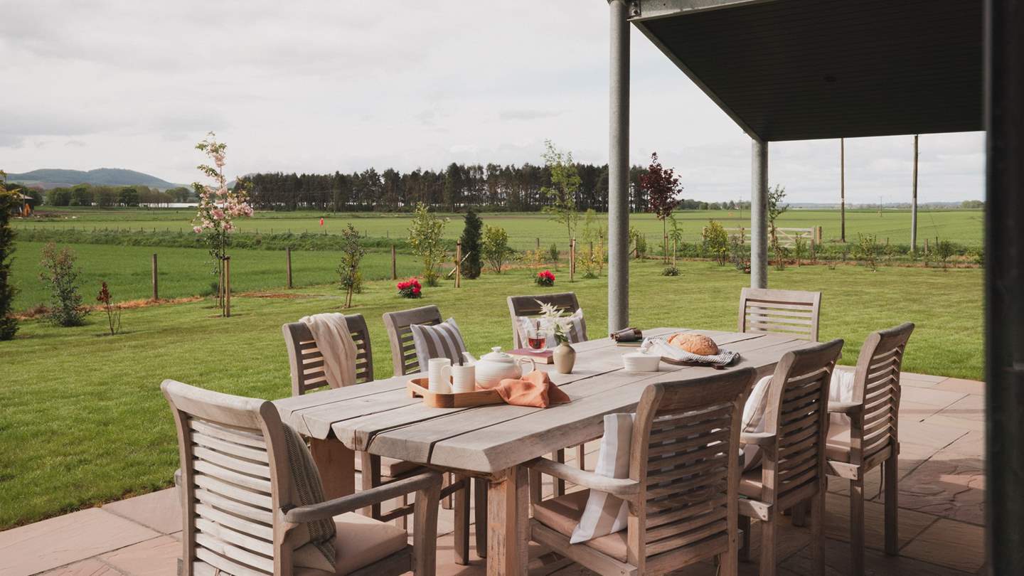 Lending a comfortable space for decadent dining is an outdoor dining table and chairs for eight