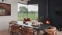 For shared moments, a spacious dining table with space for six awaits before a wood burner-effect gas stove