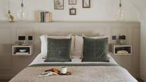 The king size bed is draped in the finest linens and topped with cushions and throws