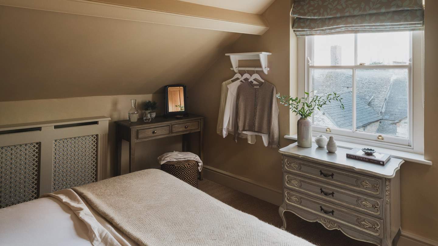 An antique chest of drawers and Cox & Cox dressing table provide space to stow treasures