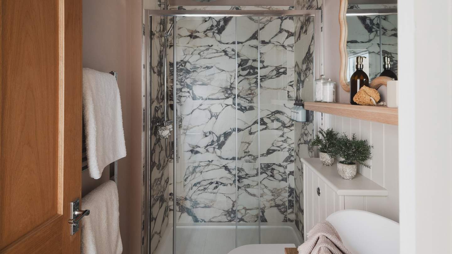 Also found on the second floor, the bathroom features beautifully contrasting marble and wood