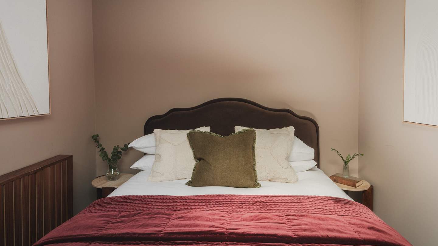 With a king-size bed dressed in comforting linens and a velvet throw in shades of merlot