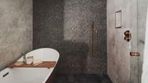Enjoy refreshing morning moments beneath the rainfall shower, alongside a copper slipper bathtub for soothing soaks