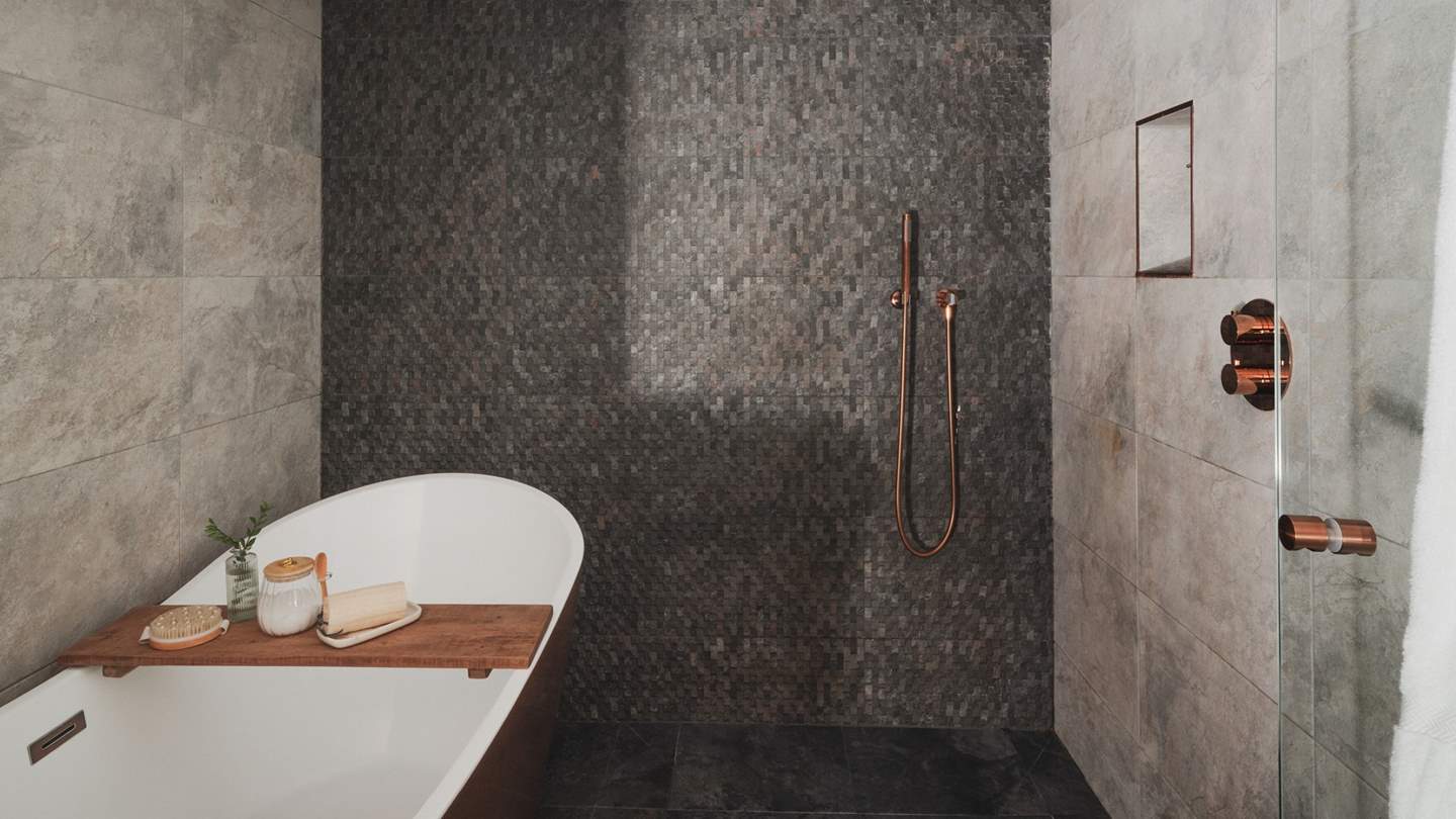 Enjoy refreshing morning moments beneath the rainfall shower, alongside a copper slipper bathtub for soothing soaks