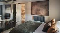 For stowing belongings, large, mirrored wardrobes are positioned before the bed