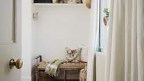 The space is complemented by a padded rustic bench and twin tallboy chests of drawers