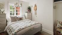 A peaceful space to rest and unwind, verdant vistas of the hills and the woodland garden lie beyond the windows
