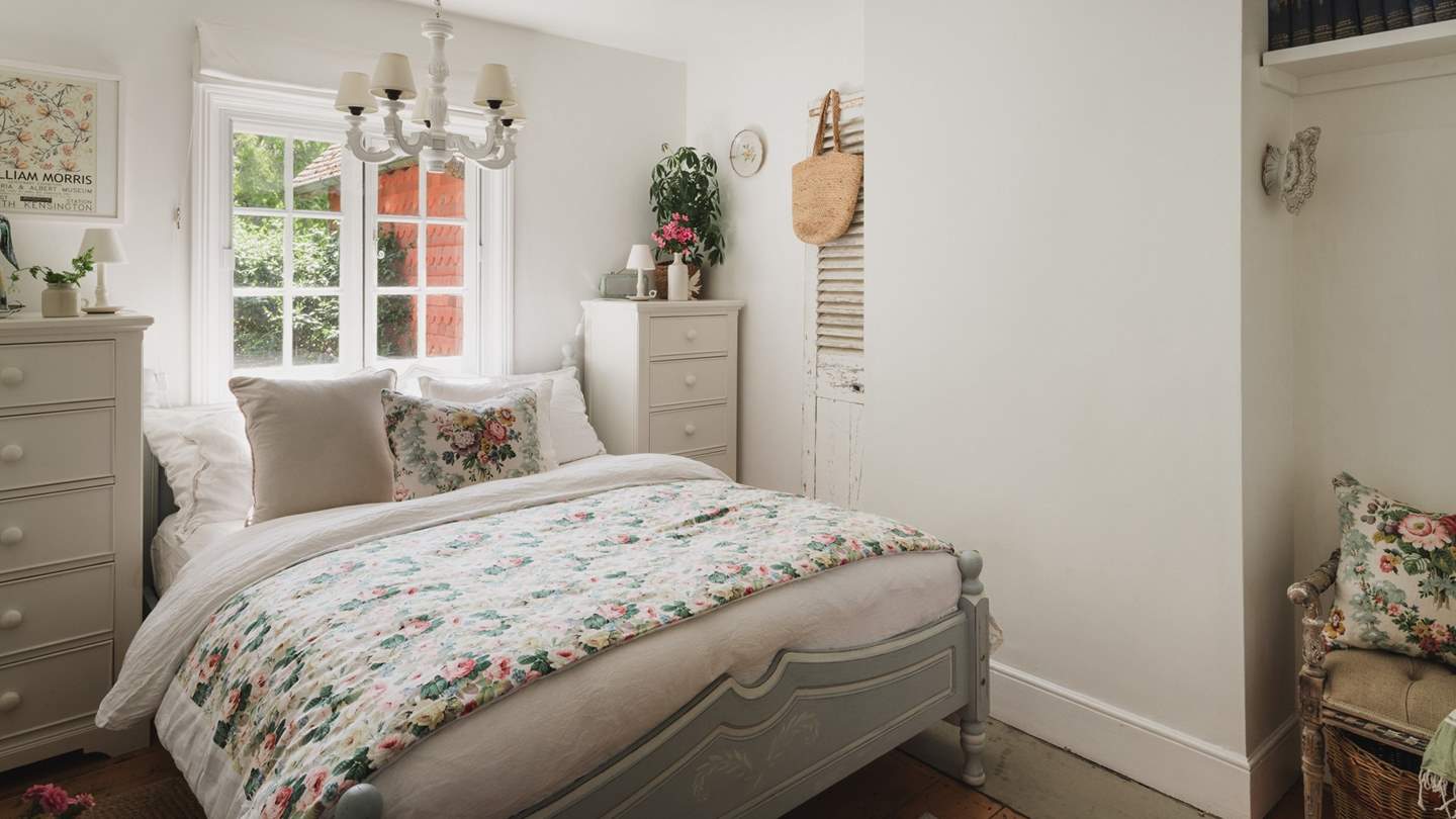 A peaceful space to rest and unwind, verdant vistas of the hills and the woodland garden lie beyond the windows