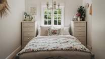 Bedroom two is equally charming with a king size bed draped in layers of soft floral linens