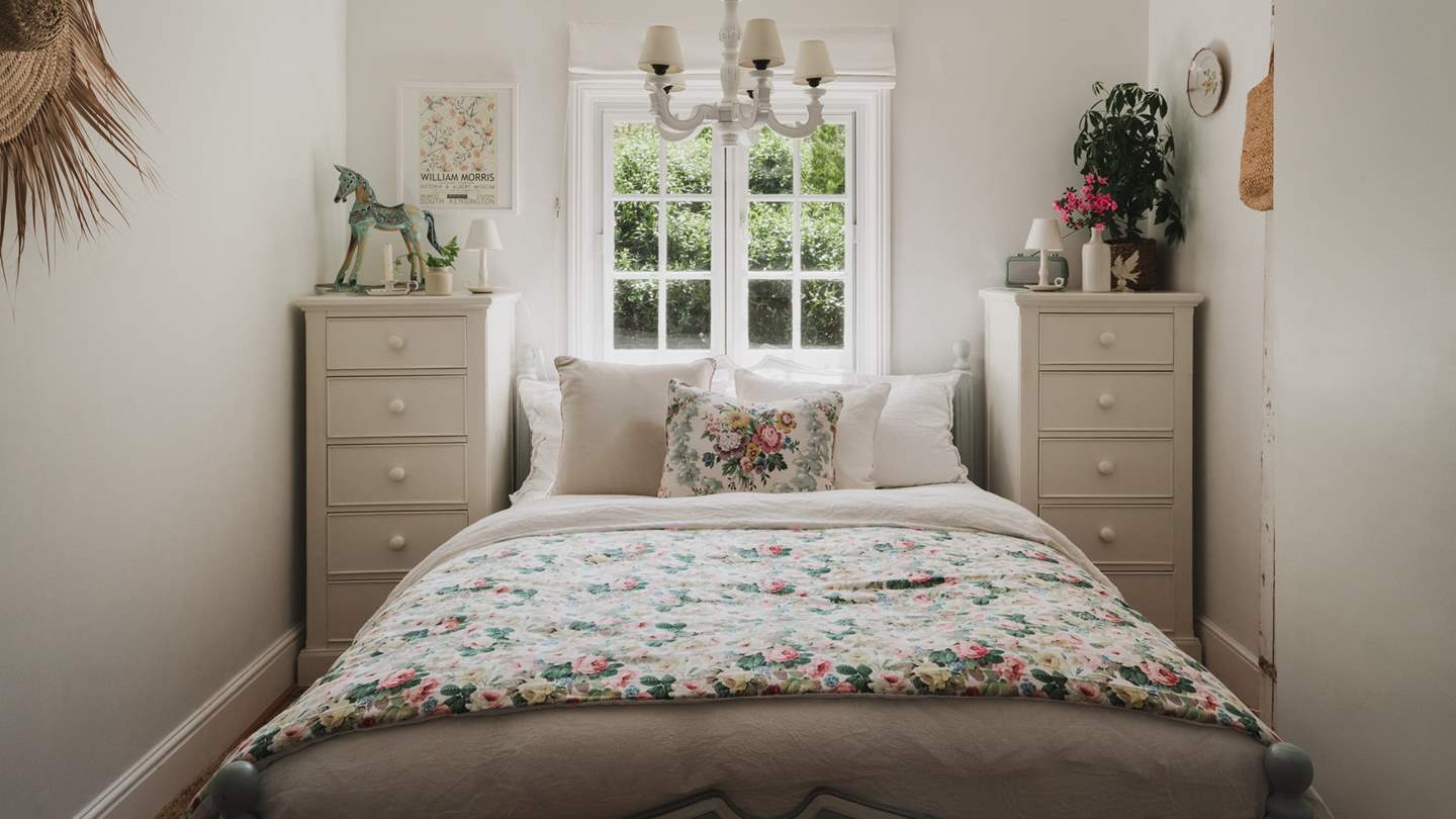 Bedroom two is equally charming with a king size bed draped in layers of soft floral linens