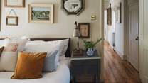 The king size sumptuous sleigh bed is dressed in crisp cottons and a bespoke quilt stuffed with carded wool from the family farm