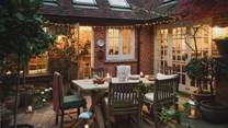 As night falls, twinkling fairy lights adorn the courtyard, transforming it into a magical setting for evenings cocooned in cosy blankets