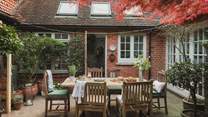A characterful courtyard filled with potted plants and trees promises a secluded space for alfresco dining
