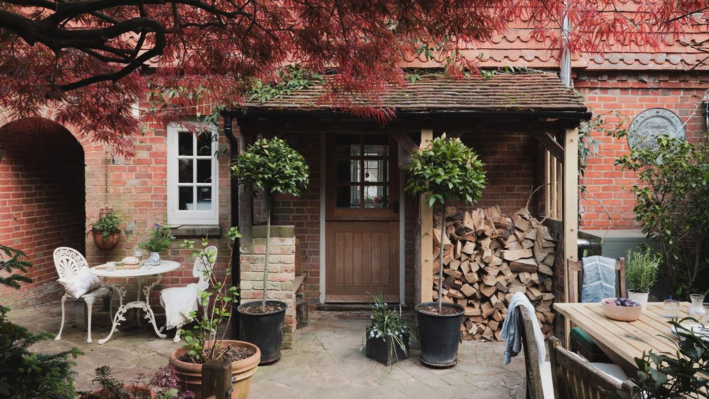 The characterful courtyard is filled with potted plants and trees 